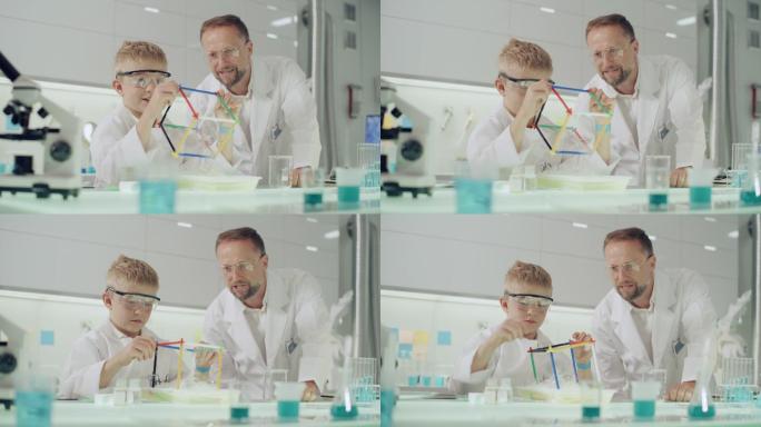 和老师一起做科学实验的男孩。在实验室里玩得开心。用肥皂泡液体研究表面张力
