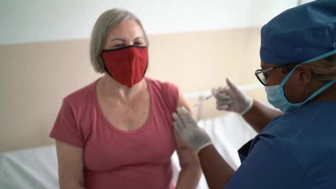 老年妇女接种疫苗-戴口罩