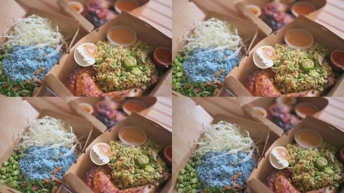 桌面视图马来西亚食物nasi Keraub、nasi ulam和ayam percik，放在带酱汁的