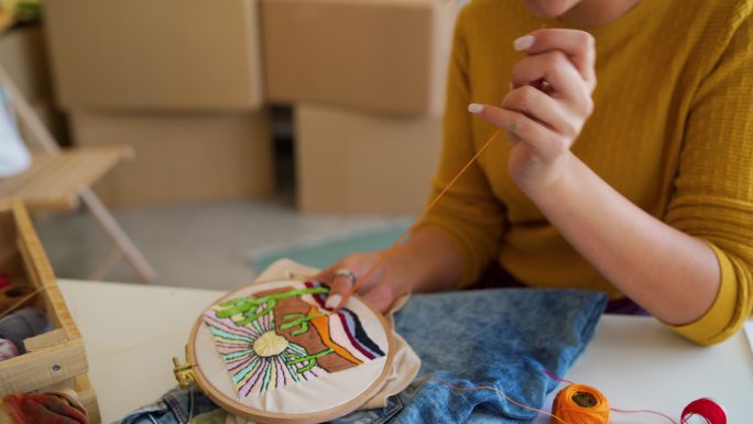 创意女艺术家，刺绣有趣的动机，来自她的家庭工作室