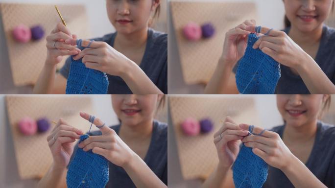 快乐的亚洲女性坐在起居室编织和钩编一把拍子，作为她的业余爱好，开始做小生意