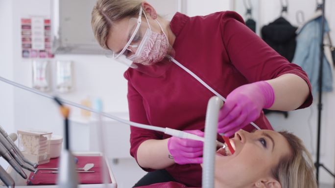 白人女牙医检查患者的牙齿
