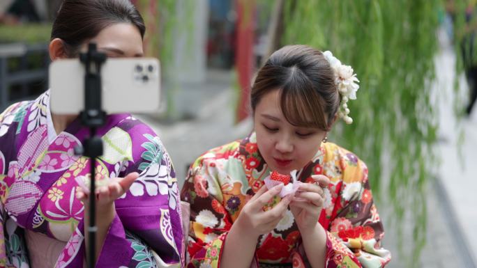 穿着和服的年轻女性朋友在街上吃美食