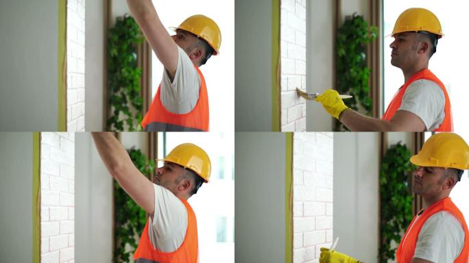 帅哥在家里刷墙。刷墙安全帽工人