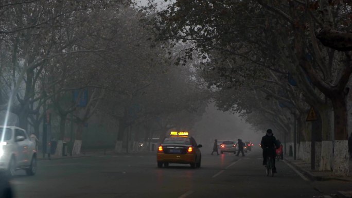 清晨街道上的行人和车辆，烟雾笼罩