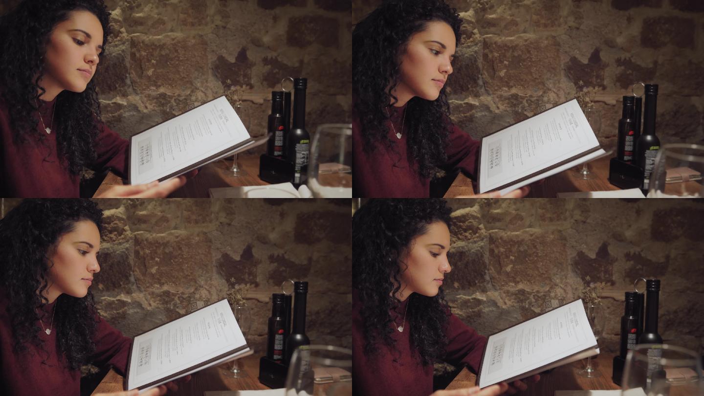 西班牙裔年轻女子在餐厅阅读菜单并点餐