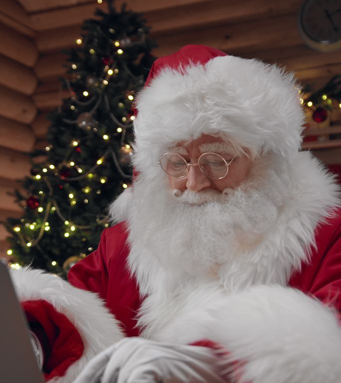 穿着华丽服装的圣诞老人想出了一个主意，开始在笔记本电脑上输入信息