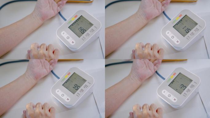 资深女性在家用医疗器械检查血压计和心率。