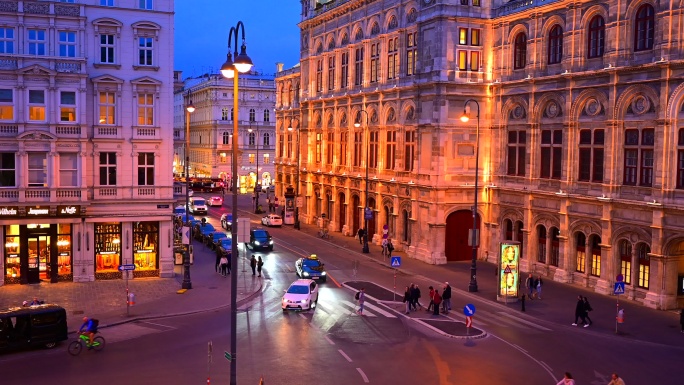 奥地利维也纳，维也纳歌剧院前的交通道路和行人的日落景象