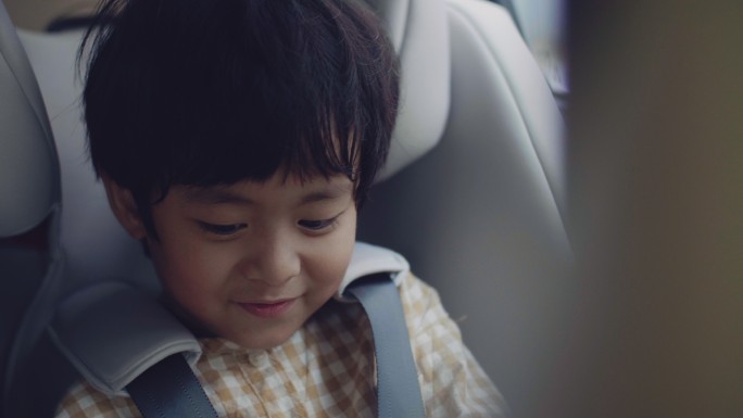 儿童安全汽车座椅上的亚洲男孩。