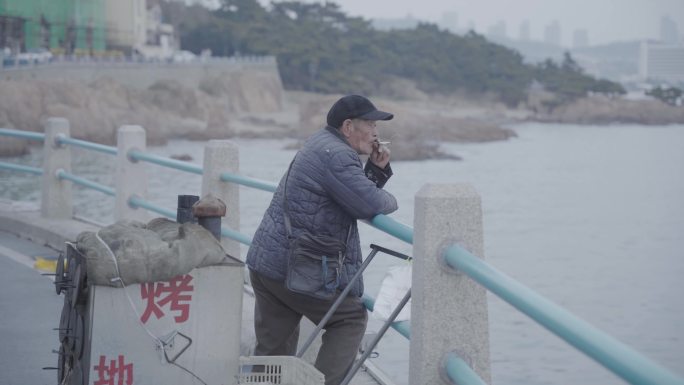 海边沉思的卖地瓜的老人