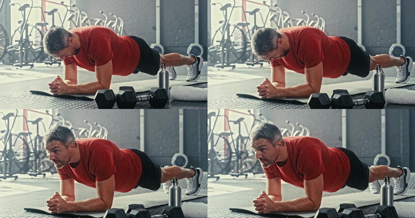 一个英俊的成熟男子在健身房锻炼时保持着支架式姿势的4k视频片段