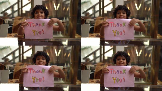 家里拿着写着“谢谢”的纸的女孩-网络摄像头视角