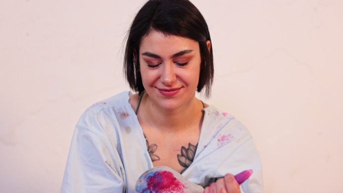 富有创造力的女艺术家展示了她沾满紫色颜料的脏手