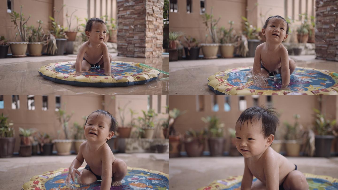 微笑的蹒跚学步的男孩在充气泳池中玩耍