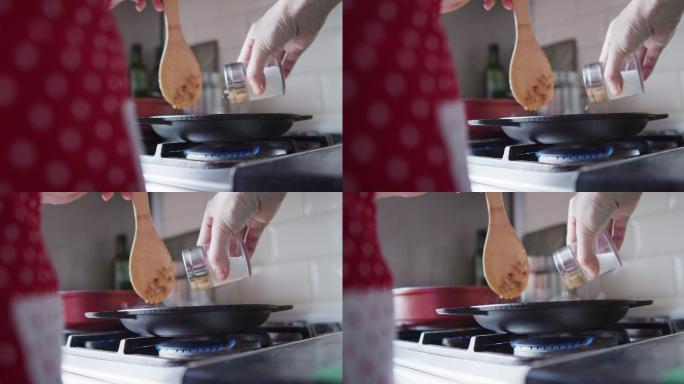一个面目全非的女人正在家里厨房里煎的食物里加盐
