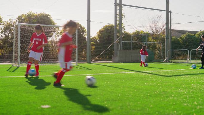 女子儿童足球或足球队练习运球