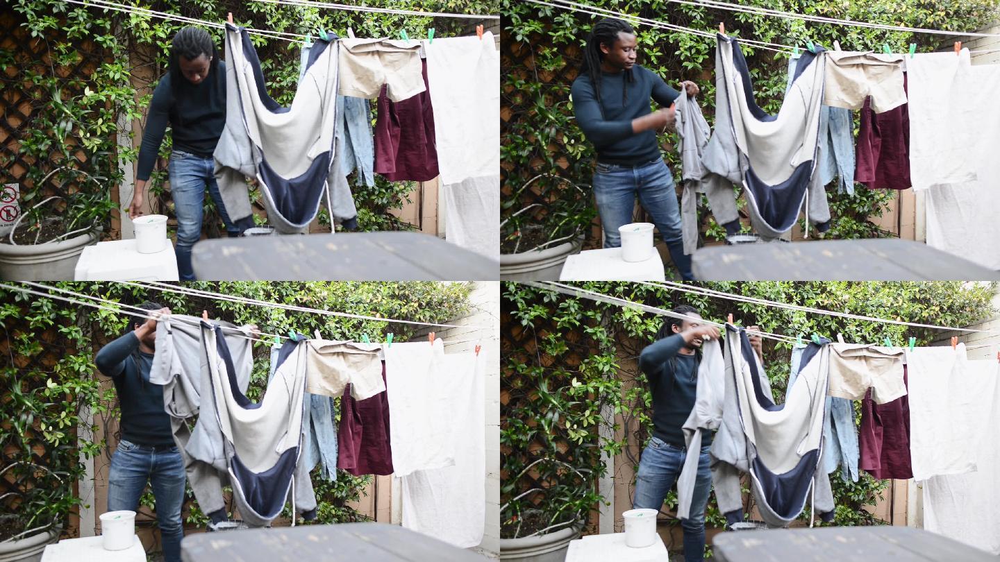 一个年轻人把洗过的衣服挂在院子外面的晾衣绳上