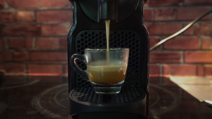 浓缩咖啡从自动咖啡机滴入杯中