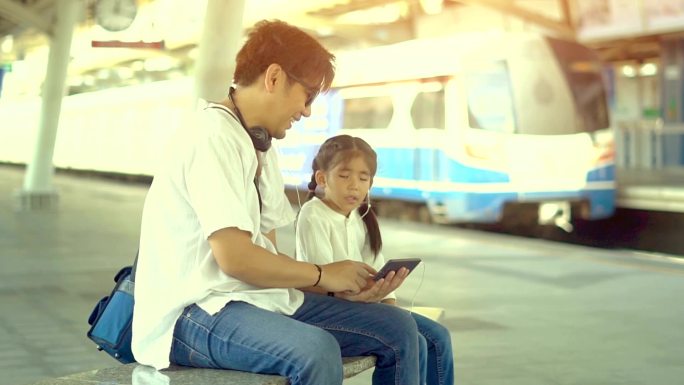 火车站单亲爸爸或单亲继父和女儿触摸屏手机