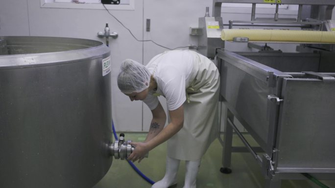 在乳品厂操作重型机械的女性