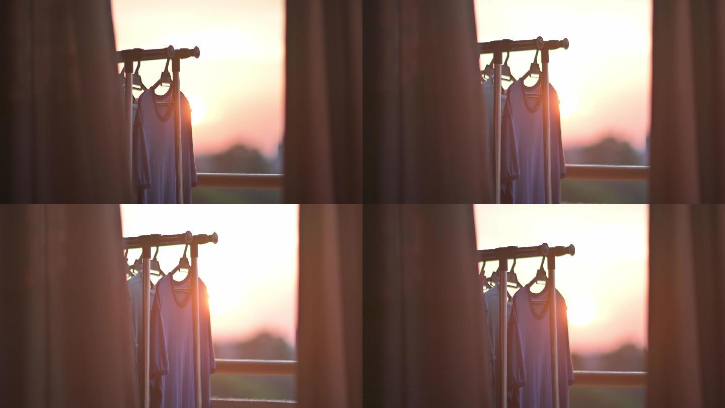 夕阳透过窗户望着城市，阳台上挂着湿布晾衣绳和衣夹