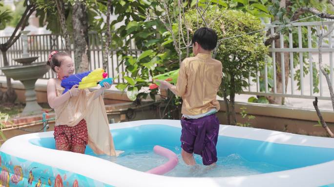 泼水节穿泰国传统服装的孩子们玩水枪
