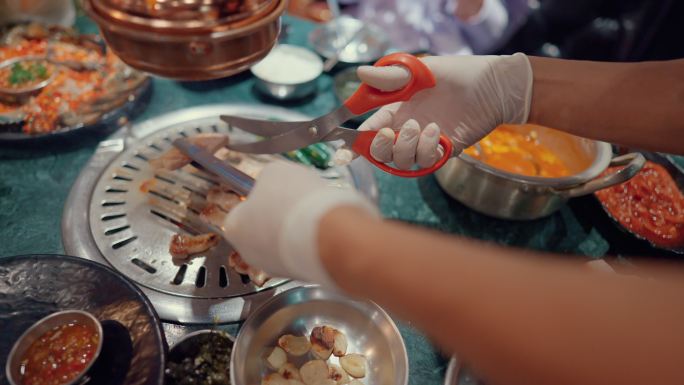 在新冠肺炎大流行期间，身着制服的亚洲服务员穿着个人防护装备为顾客提供食物。