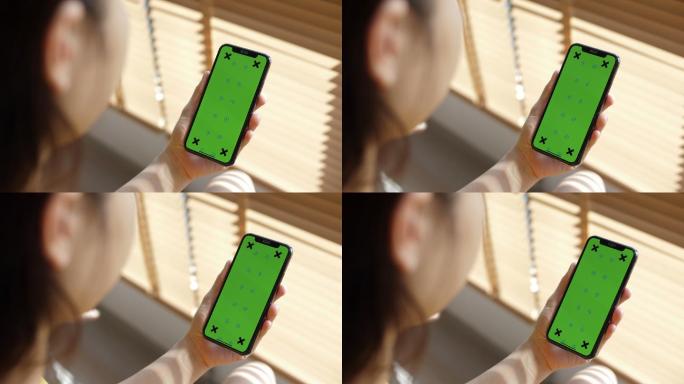 女性使用带有绿色色度键屏幕的智能手机