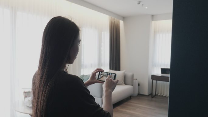 女士手持数字平板电脑和手机，使用增强现实应用程序模拟家居装饰