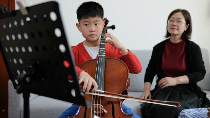 小男孩与老师在家练习大提琴的全景图