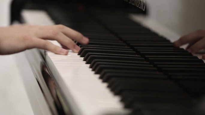 年轻男孩双手演奏钢琴曲弹钢琴琴键特写素材