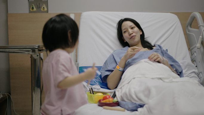生病的母亲和女儿在医院玩耍