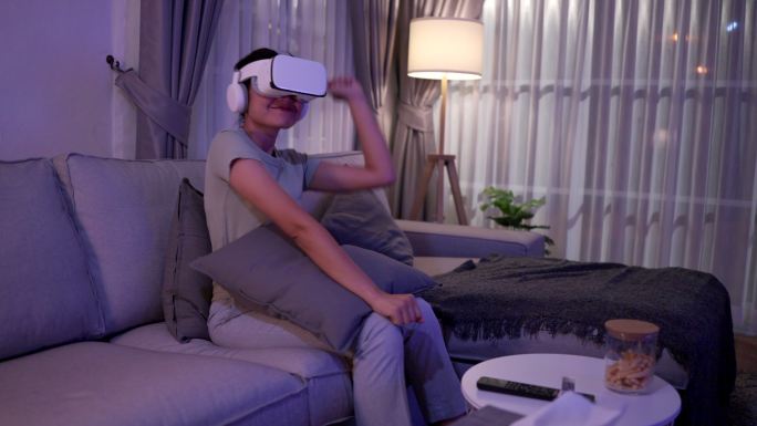 她在家的起居室通过VR眼镜观看了虚拟现实中的音乐会。