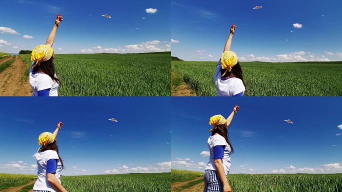 一个女人在麦田上空的晴空中放风筝。童年的乐趣。