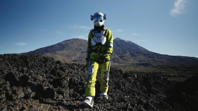在荒凉的星球上漫步。女宇航员探索灰色山脉。查看视图
