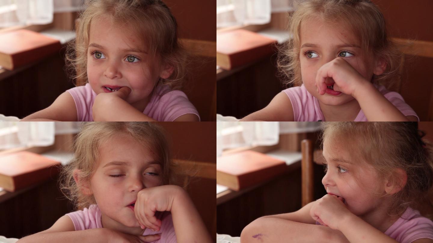 一个小女孩用手指扭动疼痛的牙齿的特写镜头