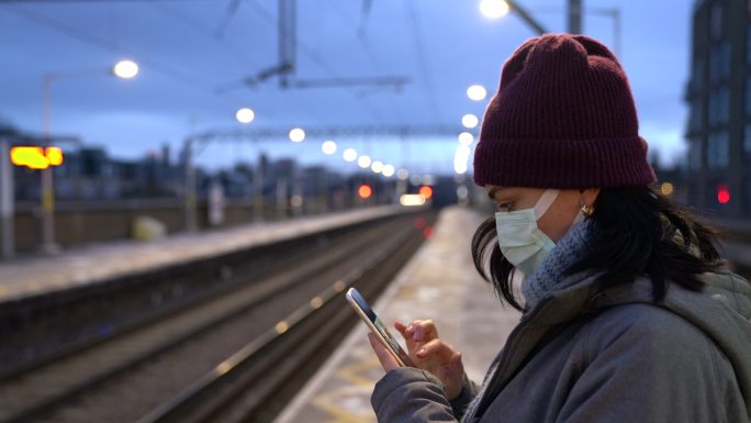 在火车站戴口罩用手机的女人
