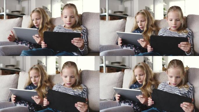 两名年轻女孩坐在家中使用数字平板电脑的4k视频片段