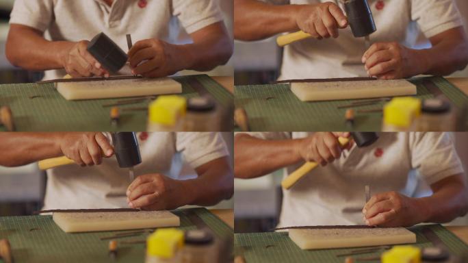 特写亚裔中国资深男子在工作室从事手工皮革表带皮革制作