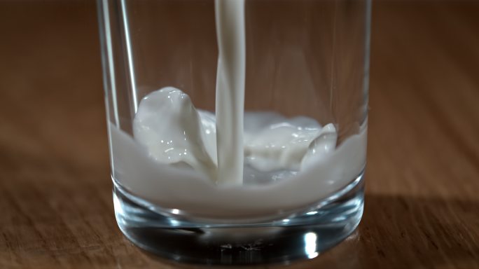 SLO MO将牛奶倒入玻璃杯中