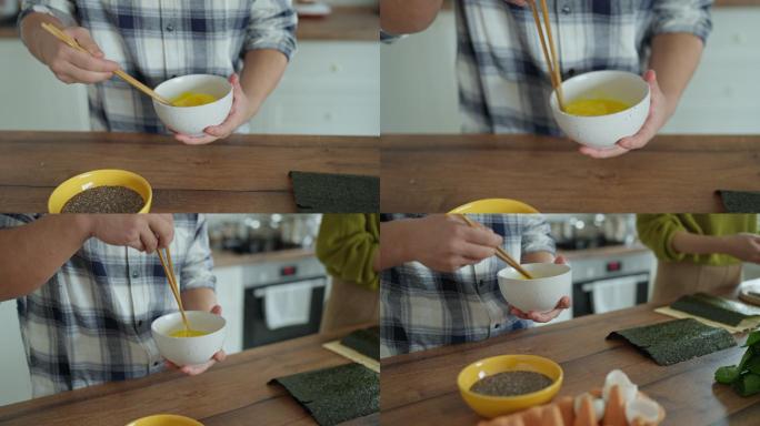 面目全非的男人，用筷子在碗里搅拌鸡蛋