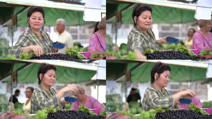 日本少数民族妇女在农贸市场购买Jabuticaba/Jaboticaba