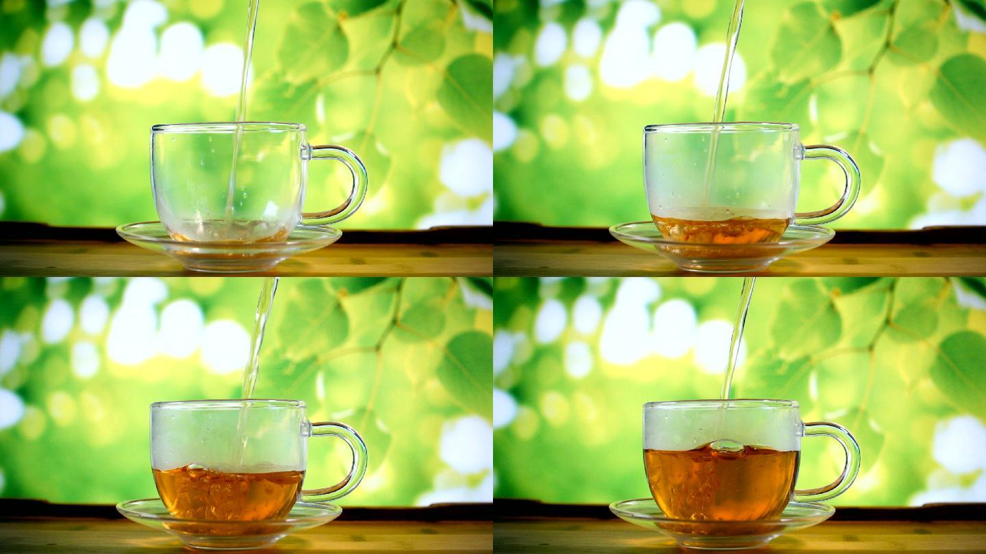 在玻璃茶杯里倒水养生茶品茶绿色优雅背景