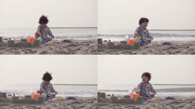 可爱的男孩在沙滩上玩沙子，玩得很开心。
