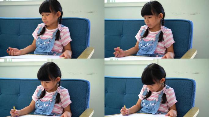 小女孩用蜡笔在画板上写生