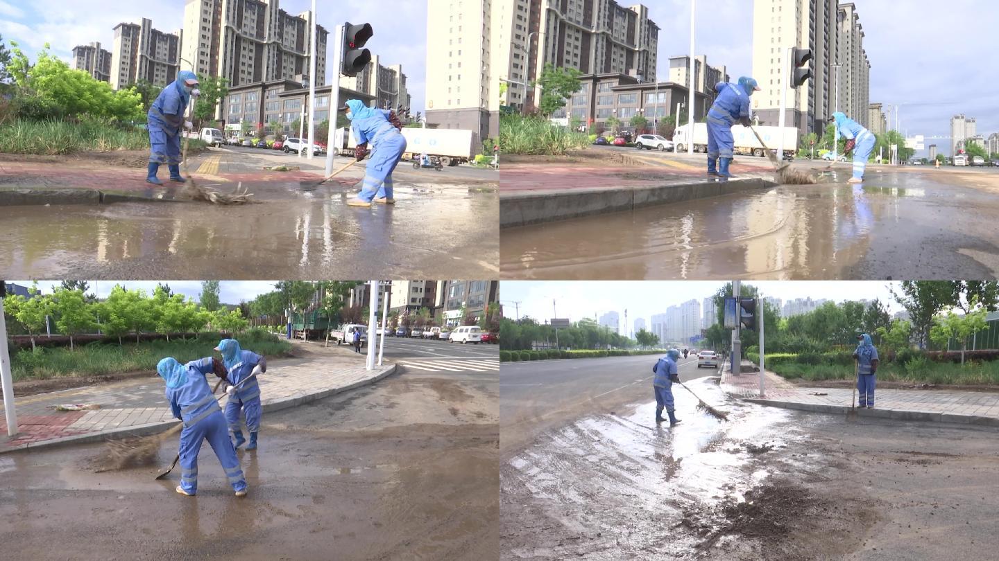 雨后环卫工人清理路边积水淤泥