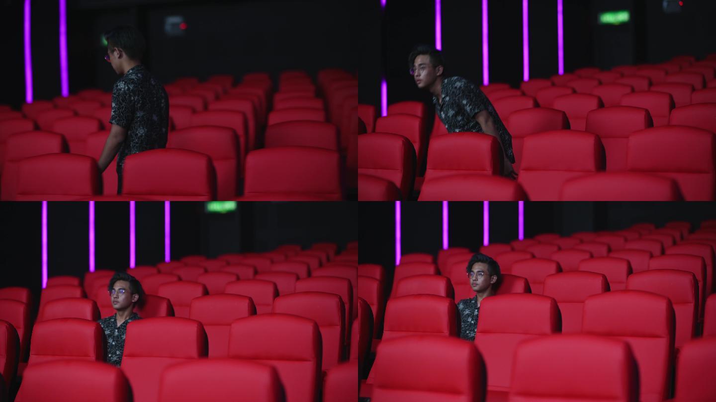 中国亚裔少年独自在电影院看电影，表情茫然