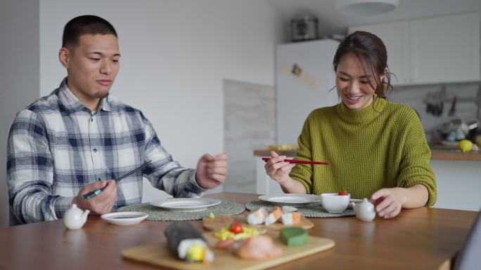 快乐的日本年轻夫妇，午餐吃寿司卷