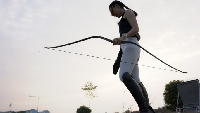 近距离拍摄在射箭场练习射箭的迷人亚洲女性。